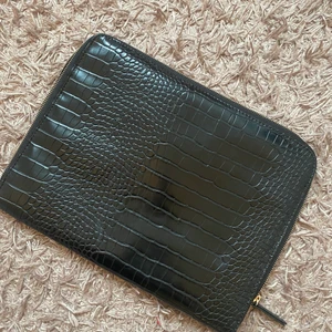 Datorfodral  - Säljer detta fina datorfodral i nyskick. Köptes i våras o har knappt aldrig använts. Det har krokodil-”skinn” på ena sidan och vanligt ”skinn” på andra sidan samt ett stort fack inuti som är perfekt för tex laddare. Dragkedjan är guldig. Skriv för mer bilder/frågor! Köparen står för fraktkostnaden 🥰😇