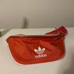 Adidas magväska - Magväska från adidas. Rymmer väldigt mycket och har en ficka på insidan. Är mer rosa än på bilden!