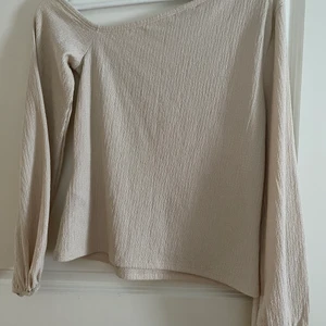 Sne skuren blus - En sen skuren blus från NA-KD i storlek M, i en beige färg och lite ribbat material. Nästintill aldrig andvänd😊