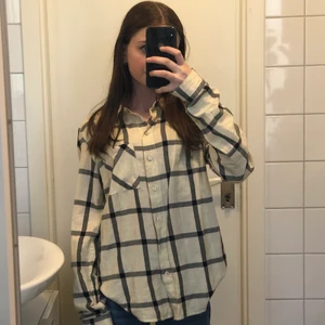 Skjorta - Jätte fin beige skjorta från HM i storlek 32. Det är svart/grå och neongröna ränder på. Använd en gång. 😊 Säljs pga tappt intresse och används för lite.