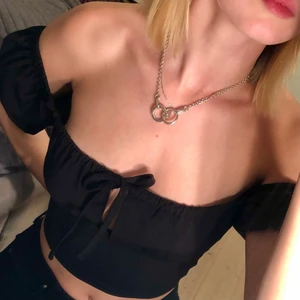 Svart topp med knytning från Asos - Säljer min svarta topp då den inte kommer till användning. Aldrig andvänd från asos storlek 34, nypris 179kr. Knytning över brösten, korta fluffiga ärmar och djup rygg.   Kontakta för fler frågor. Pris kan alltid diskuteras!