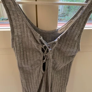 Topp från Urban outfitters - Grå topp från Urban outfitters med knytning, använd en gång 
