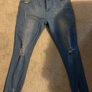 Jeansbyxor - Jeans med hål vid knäna och slitna nedtill