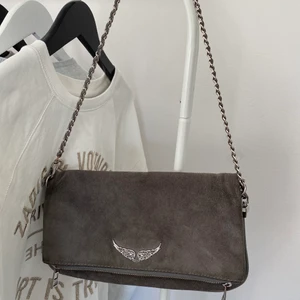 ZADIG VOLTAIRE VÄSKA - Hej! Tänkte sälja min Zadig Voltaire väska som jag fick i födelsedagspresent för några ett år sedan! Säljer då jag inte använt den på länge. Den är fortfarande helt ok skick, förutom att silvret på sidan har börjat bli lite rosa (inget man märker av) och beror främst på att kedjan och ringen har liksom gnuggat ihop sig och då har lite av det silvriga färgen åkt av. Har som sagt haft den ett bra tag och det är därför jag säljer för bra pris. Modellen heter ”Pochette Rock Suede” och kostade 3600kr. Skriv till mig privat om ni har några frågor eller är intresserade! FRI FRAKT❤️