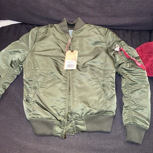 Alpha industriers jacka - En helt ny alpha industries jacka med lappen kvar som var för liten för mig. Skit snygg med orange innuti, vill helst ha den såld för så nära orginalpriset som möjligt eftersom jag vill köpa en annan i min storlek.