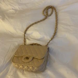 Axelremsväska  - Berge axelremsväska med gulddetaljer och rutmönster