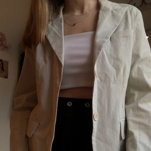 Randig kavaj i strl 38 - Vit kavaj med svarta ränder. Köparen står för frakt. 