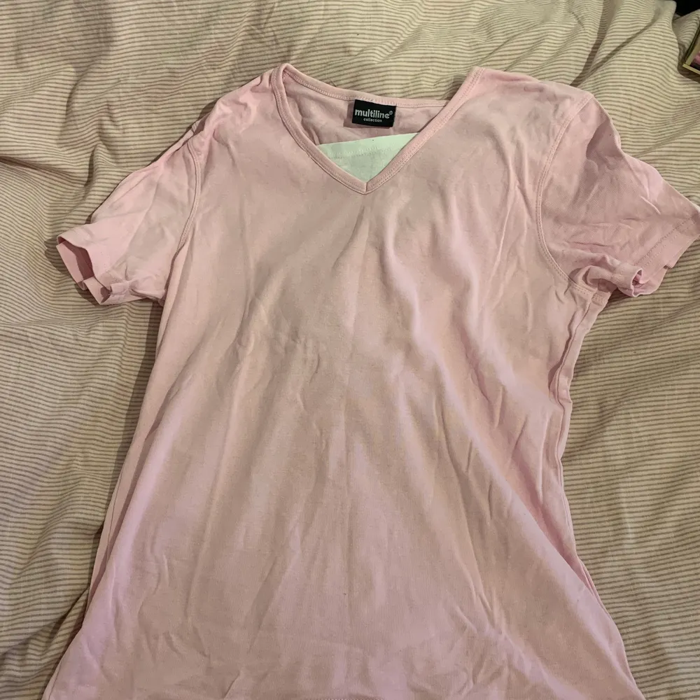 En rosa t-shirt som har en vit strand vid brösten och som har skönt material, passande för sommaren!. T-shirts.
