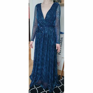 Blå/turkos glittrig långklänning - Helt ny endast provad långklänning i blå/turkost skimrande material med paljetter. Storlek S/38, perfekt till nyårsfirandet! 