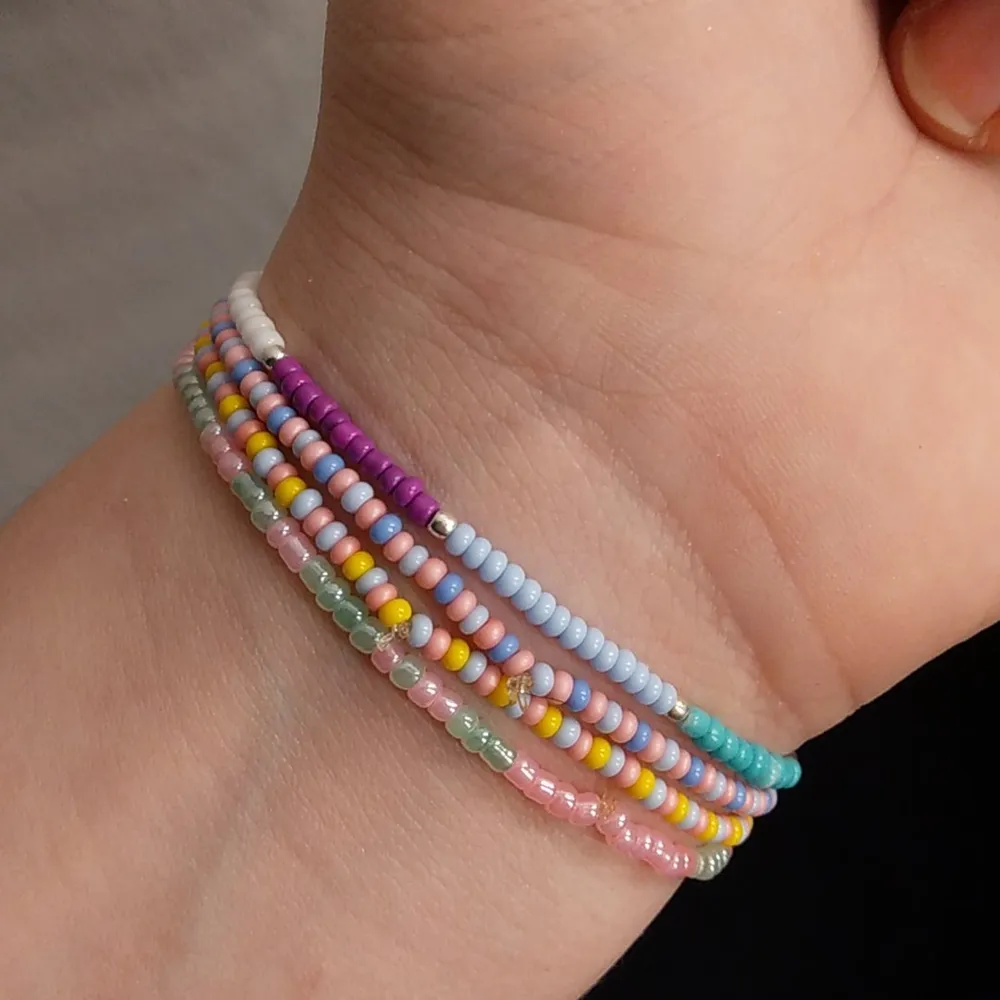 Fyra Multifärgade armband med många rosa pärlor.  Det är stretch på tråden och passar de flesta. Accessoarer.