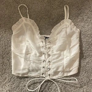 Korsett top - Säljer denna korsett aktiga top från shein. Det går att spänna upp snörningen eller att spänna åt den. Tyget i ryggen är även töjbart. Använd 1 gång💕 Köparen står för frakten⚡️