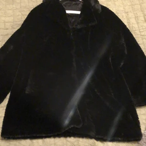 Svart pälskappa - Svart pälskappa i storlek 42/44. Säljs pga att den inte behövs mer.
