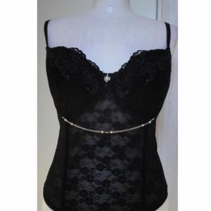 vacker korsett topp svart stl 70C - detaljer: har typ ett hjärtdetalj i mitten och strass. svart spets korsett topp storlek 70C byst, (M). köpt sent 90-tal/tidigt 2000-tal. möts endast upp (stockholm) 👾