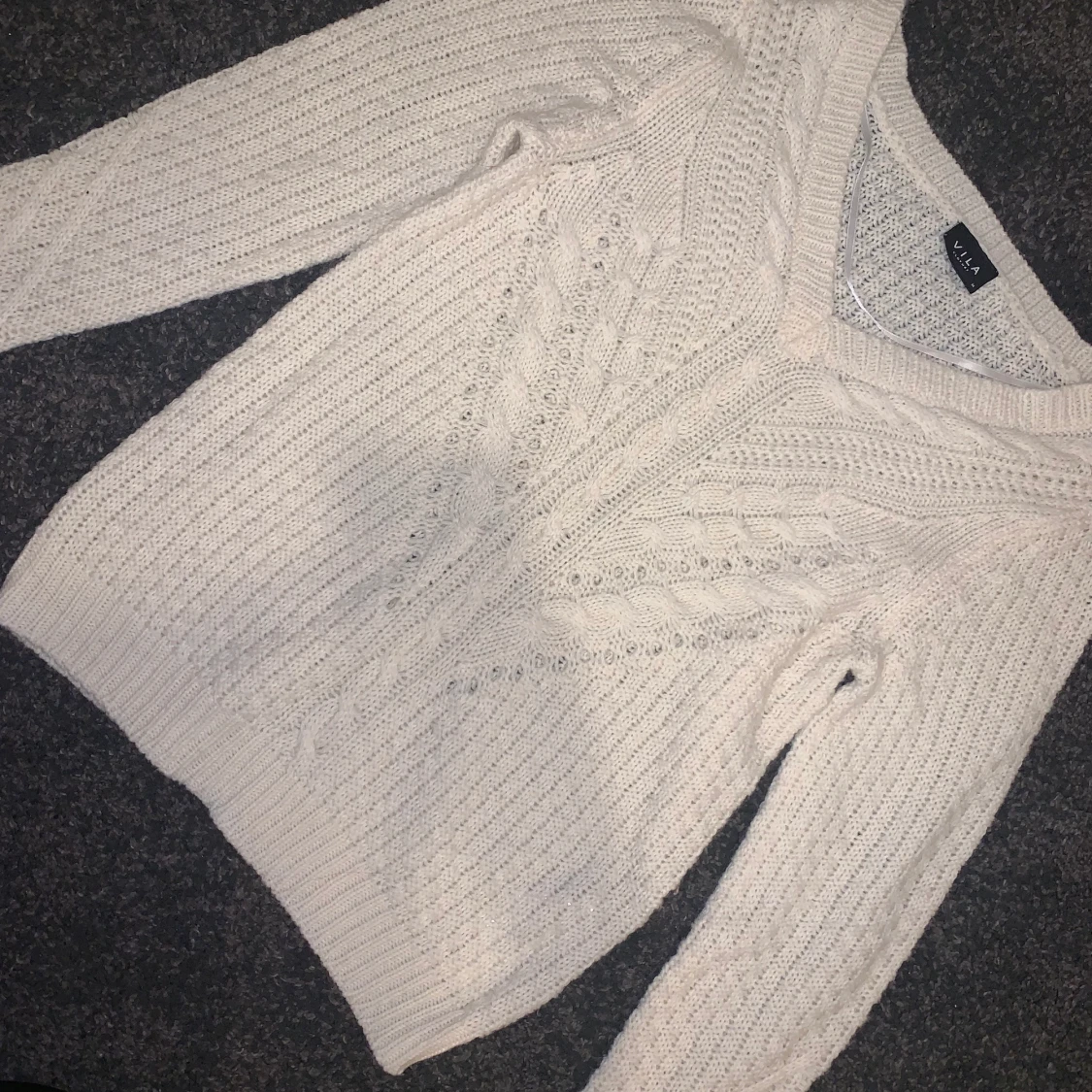 Stickad krämvit tröja med v-ringning.  - 90