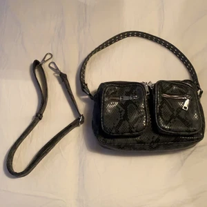 Noella väska ormskin  - Jag säljer denna fina noella väska jag köpte för ett kort tag sen! Den kommer tyvärr inte till användning, den är använd några få gånger och är inte alls sliten och i super bra skick!❤️ original pris 800kr, buda från 350kr🤩 Köparen står för frakten!