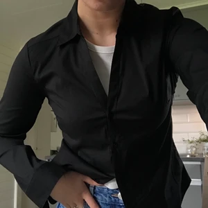 Svart skjorta - Jätte snygg skjorta som formar sig bra vid kroppen, säljer en likadan vit också! 💕aldrig använd (pris kan diskuteras)