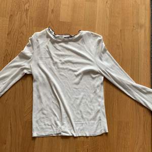 En vit långärmad tröja med svarta räfflade kanter från Zara. Tröjan är i storlek S och i använt skick.
