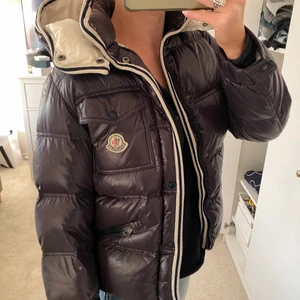 Jacka - Dunjacka från moncler, storlek 12 och är typ mörklila/brun, nästan svart! Själva ”flärpen” på dragkedjan är borta (ser mörkare ut i verkligheten, så som bild 2). Självklart äkta
