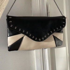 Väska med dödskalle  - Säljer denna fina väskan köpt här på plick. Vet tyvärr inte vart den kommer ifrån, men den är super fin och är i jätte bra skick🤩 bandet är egentligen långt, men jag har valt att snurra det kortare, vilket man kan bara ta tillbaka om man vill ha det långt igen❤️ köparen står för frakt!