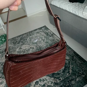 Brun handväska från MONKI - Brun handväska från MONKI som jag köpte på PLICK men säljer då nyansen inte matchade annonsen, vilket har gjort att den inte har kommit till användning!
