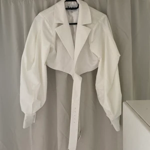 Puffärm omlottkavaj NAKD - Säljer denna skönhet då den är alldelses för stor och jag ej fattar hur man får på sig skiten. Heeelt oanvänd. Storlek 34