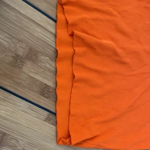Orange topp  - Orange topp ifrån ginatricot i storlek S. Toppen är klippt både på längden och att till en v-ringning. Den är väll använd. 