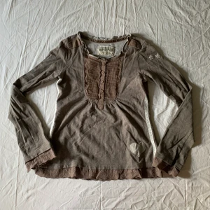 Gråbrun tröja med spetsdetaljer - Tröja från Chill Norway! Är gråbrun i färgen med vit spets längs sidan. Knappt använd då den inte passar mig perfekt. Bra skick!