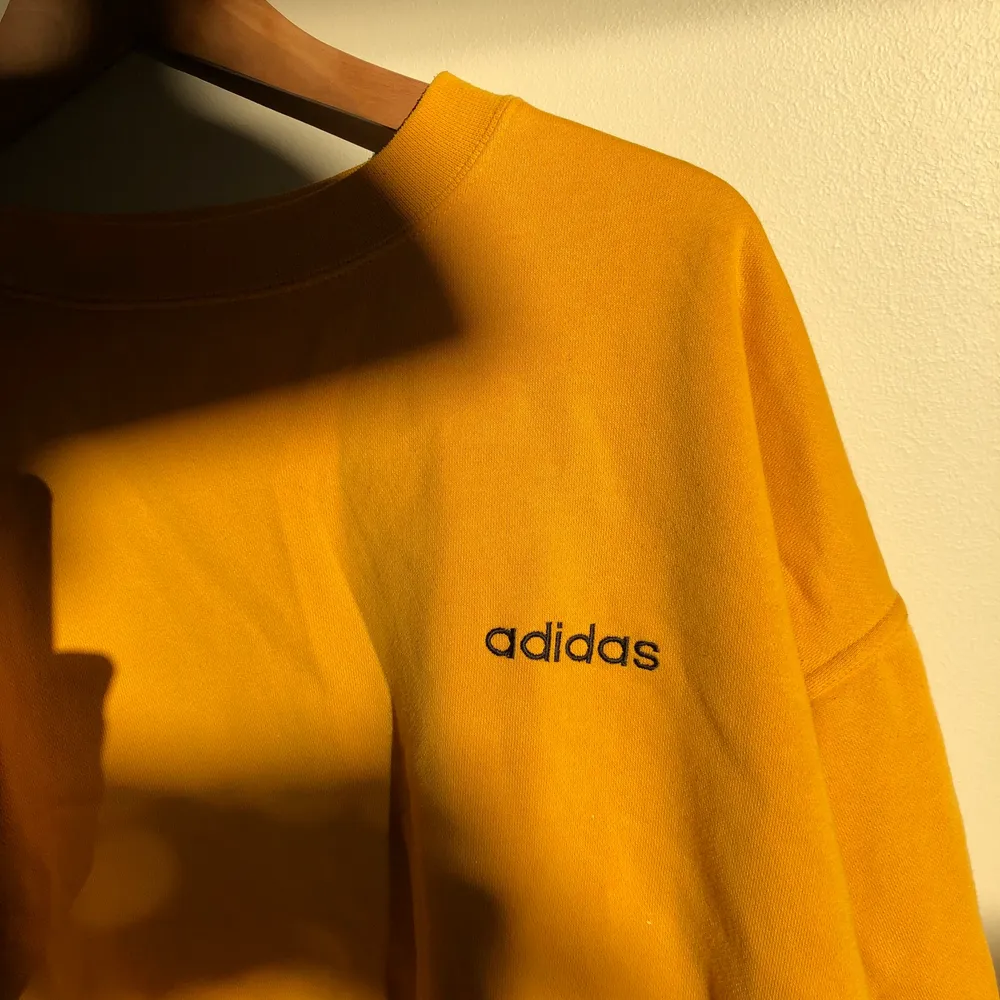 Adidas-sweatshirt köpt på vintagemarknad i Amsterdam. Bra skick, fett skön och najs brandgul färg. Ett kap!. Hoodies.