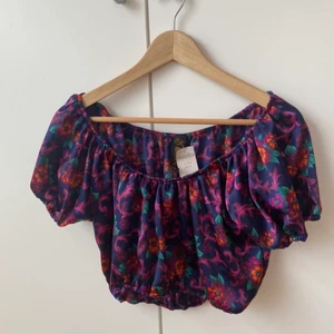 Vacker topp från Beyond Retro - Söt topp från Beyond Retro. Jag tänkte den skulle passa bra på någon temafest men den har aldrig blivit använd av mig. Storlek L men passar bra som luftigare topp om man har en mindre storlek också. Jag är storlek XS-S och tyckte den passade som lite over size. Materiallapp saknas, kanske polyester. Jag noterade två små hål när jag kollade igenom den. De syns inte vid användning.