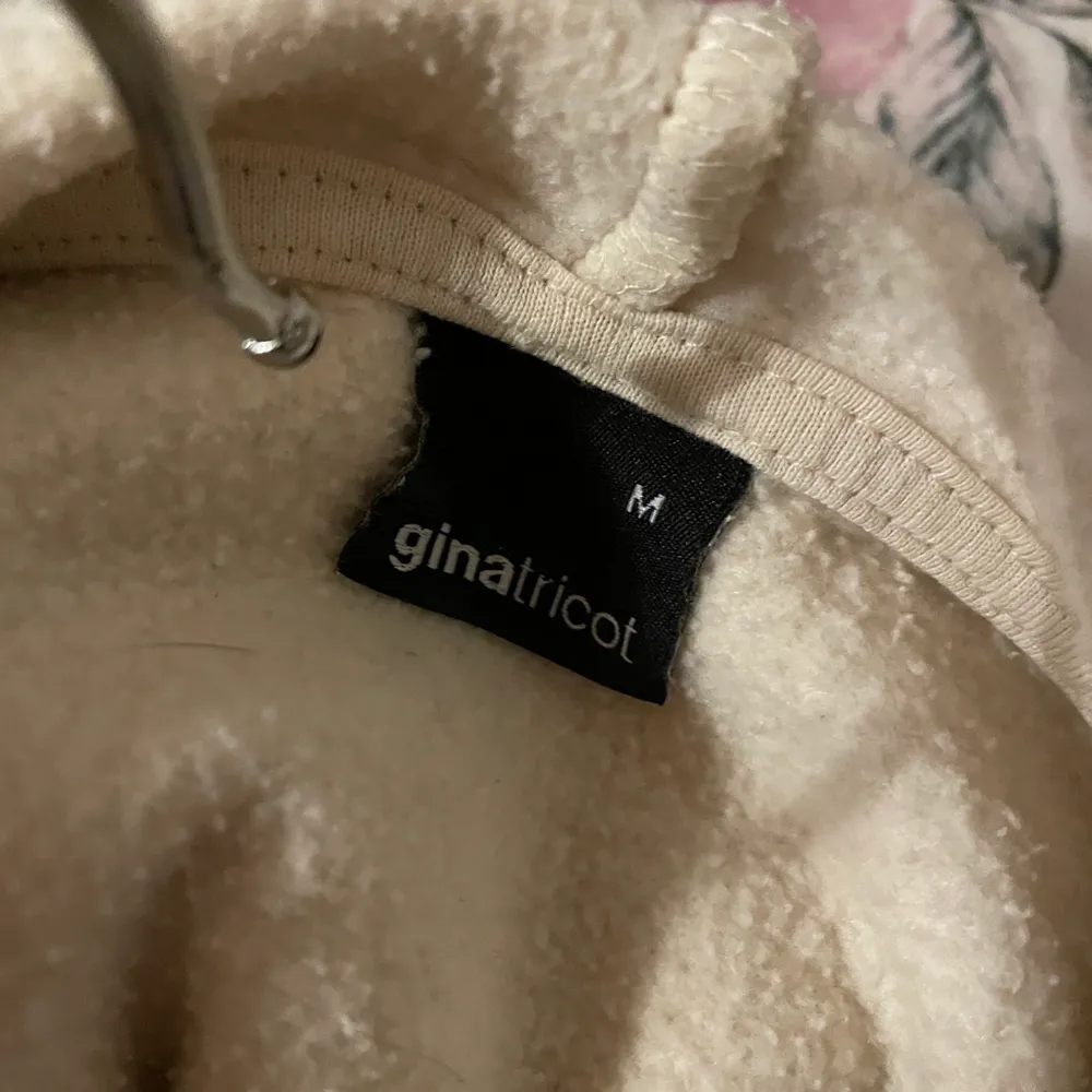 En beige hoodie med texten amoure libre på bröstet och den har även så att man kan knyta den i midjan. . Hoodies.