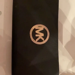 Michael kors plånbok - Säljer min Michael kors plånbok, vet dock inte om den är äkta eller inte. Haft den ungefär 1 år men använt under ca 6 månaders tid. Inga fel på den förutom att den är lite ”skrapig” vid hörnet (kolla bild nummer 3) sen även dragkedjan innanför plånboken