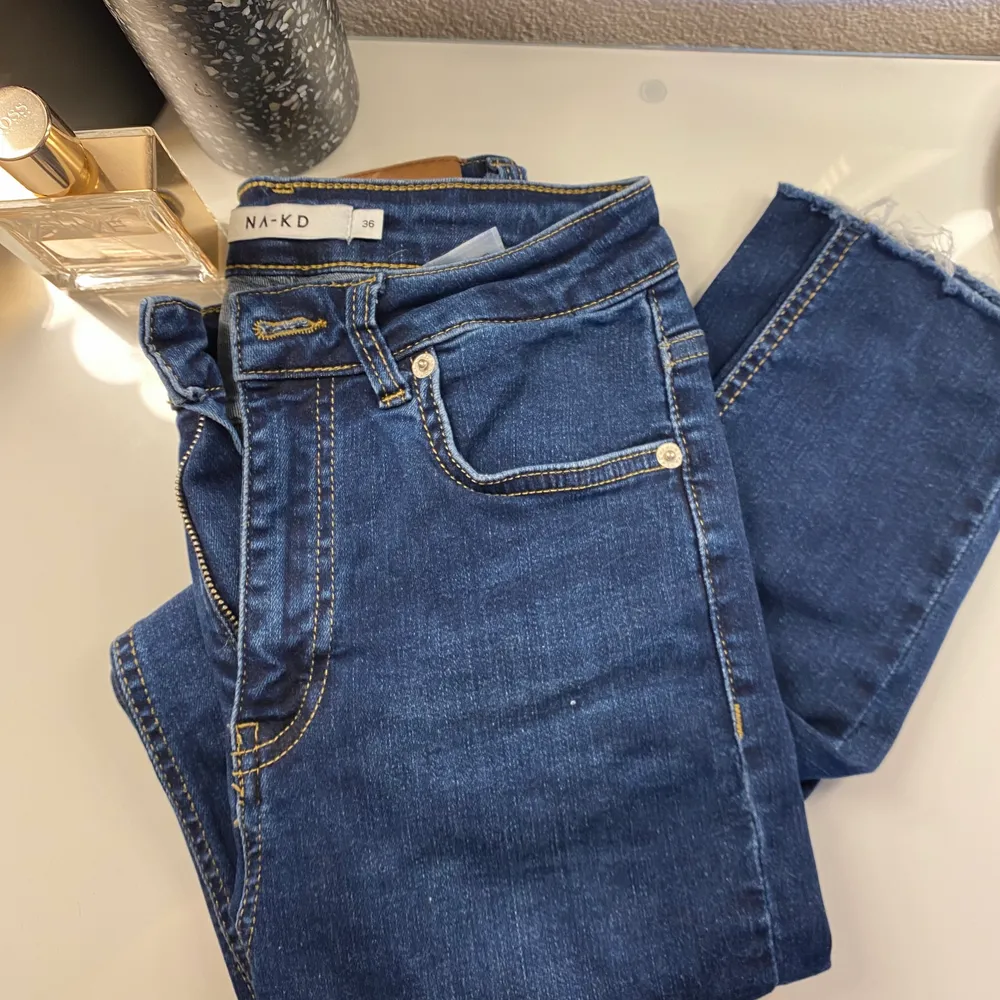 Jättefina mörkblå jeans från NA-KD med lite slitningar längst ner. Storlek S . Jeans & Byxor.