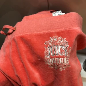 Juicy couture byxor - Aprikos färgade juicy byxor! De är lågmidjade och sitter 8 cm under naveln på mig. Modellen sitter typ som sista bilden. Fortfarande fint i tyget och bra skick. Säljer för att de inte längre passar tyvärr❤️‍🔥buda! Kan förhandla med priset💥⭐️