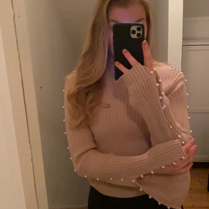 Rosa tröja med pärlor  - En rosa ribbad tröja, med pärlor längst armarna. Tröjan är i fint skick, och endast använd ett fåtal gånger. 