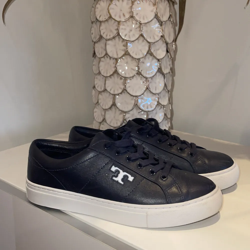 Ett par Tory Burch sneakers i skinn,  i färgen navy, inköpta för ca 1 år sedan för 1999kr, säljer för 1100 + frakt💞. Skor.