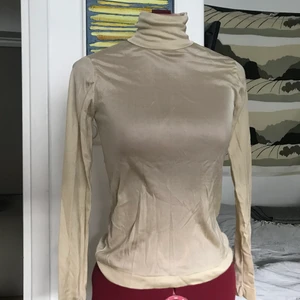 Tunn beige glansig polo - S  - Tunn glansig polo i gott skick.