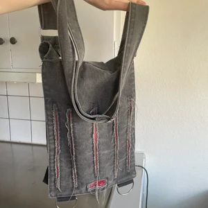 väska - crossbody väska med slitningar. skitcool men har för mång väskor för att den ska komma till användning. bandet går att justera en del