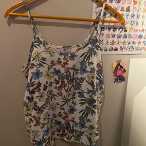 Topp - Säljer mitt blommiga linne för det inte är min stil längre :) Linnet är i storlek S men skulle också passa M. Banden är justerbara också :) 