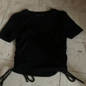 Zara T-shirt i svart. Prislapp kvar o man kan justera längden i sidorna