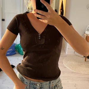 Brun tshirt med söta knappar - Supersöt tshirt med skimriga knappar. Jättefint skick! 