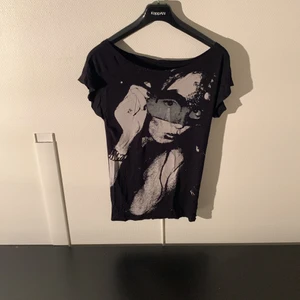 Svart T-Shirt med coolt tryck - Svart t-shirt med coolt tryck på en tjej med solglasögon. Den har även rhinestones på sig. OBS ett litet hål i botten av baksidan av tröjan