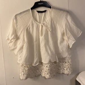 Vit blus, Zara, Strl XS - Vit blus från Zara med tofsdetaljer och mönster längst ner. 