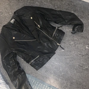 Skinnjacka storlek 34  - Säljer nu min skinnjacka då den är för liten. Storlek 34/Xs sparsamt använd. Har dragkedjor på ärmarna. Små fickor fram och mönstrade axlar som ses på bild 2. 