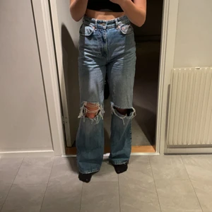 Blåa håliga jeans från gina - Fina blåa jeans från gina med hål i fint skick, säljer för att dem inte kmr till användning, köparen står för frakten