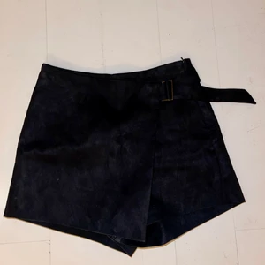 Kjol/shorts storlek M  - Supersnygg kjol/shorts i mocka-imitation! Går omlott i fram med ett spänne i sidan. Storlek M från Zara