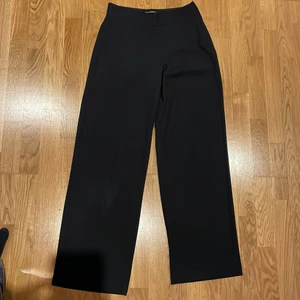 Utsvängda Kostymbyxor från Cubus - Mjuk och bekväm, åtsittande på rumpan. Bra kvalite, använd fåtal gånger,svarta kostymbyxor 