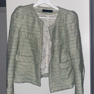 Blazer/Kavaj från Zara - En blazer/kavaj från Zara. Turkosa, guldiga och vita sömmar. Två fickor. Gott skick. Säljs inte längre. Storlek M.