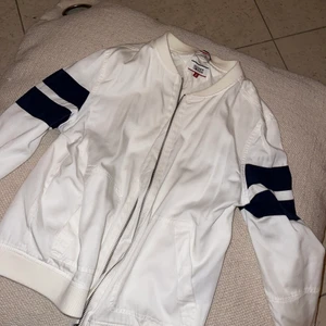Tunn jacka - Tunnare jacka i vit med marinblå detaljer från Tommy Hilfiger. Använd endast 1 gång.