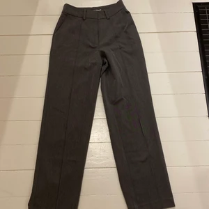 NA-KD kostymbyxor  - Gråa kostymbyxor med slits vid foten använda en gån, storlek 36