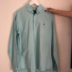 Ralph Lauren-skjorta  - Turkos skjorta med bra passform. Finns ett litet märke till vänster (från åskådarens sida). Köpare står för frakten